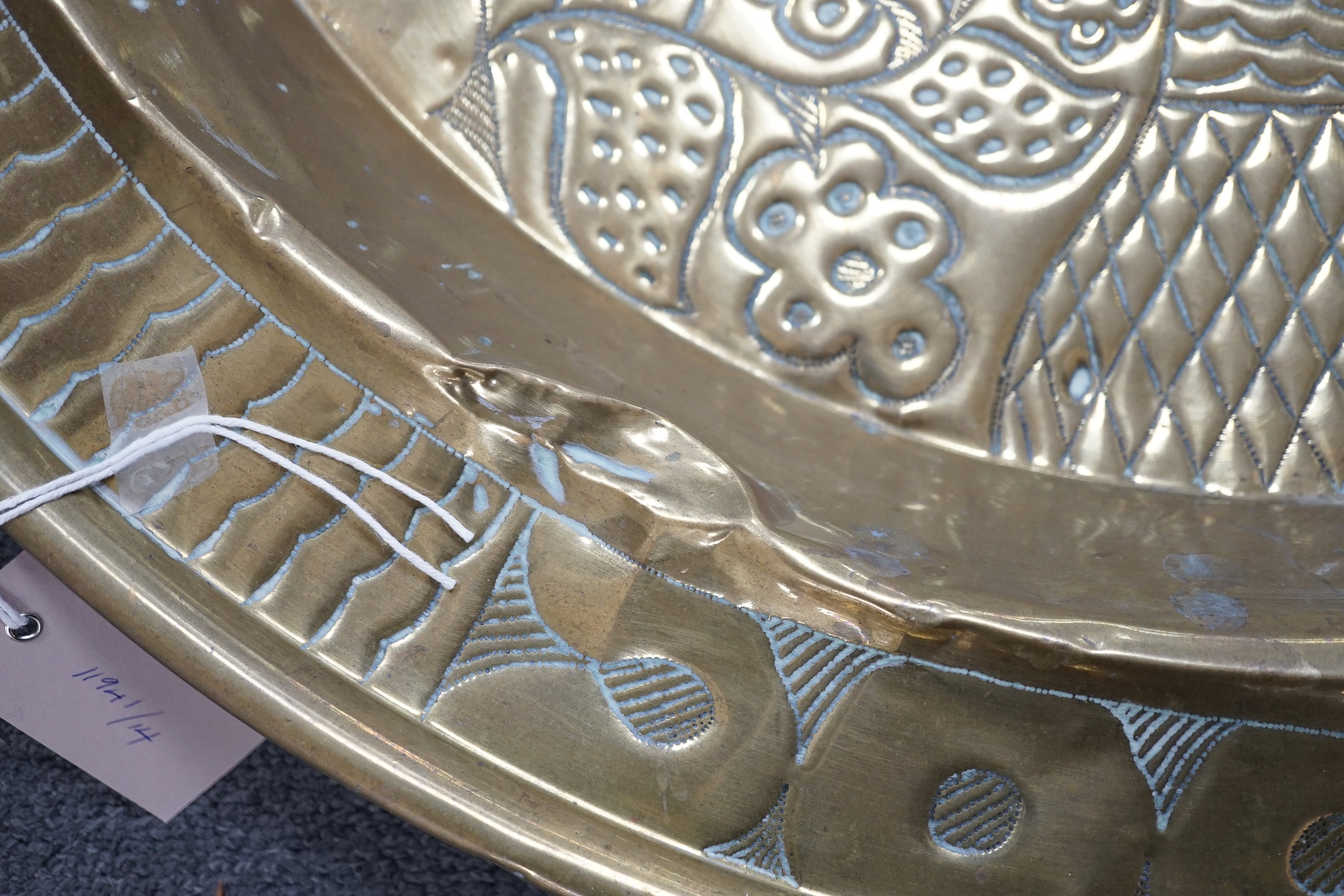 An embossed brass table top/ tray, 74cm diameter